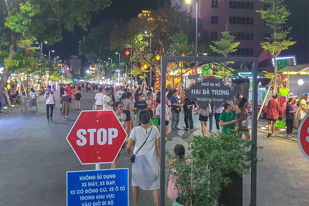 A sign with Hai Ba Trung Walking Street and another stop sign indicating no vehicles can enter this street in Hue