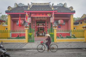 Front facade of Hai Nam Assembly Hall Hoi An with green gates and tiled roof – vibrant temple entrance along the historic streets of Hoi An Ancient Town.