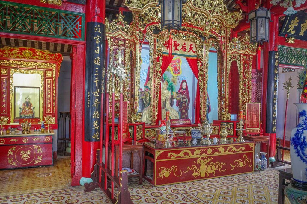 Ornate red-and-gold altar inside Hai Nam Assembly Hall, a Chinese-style temple in Hoi An dedicated to the merchants’ protector deities.