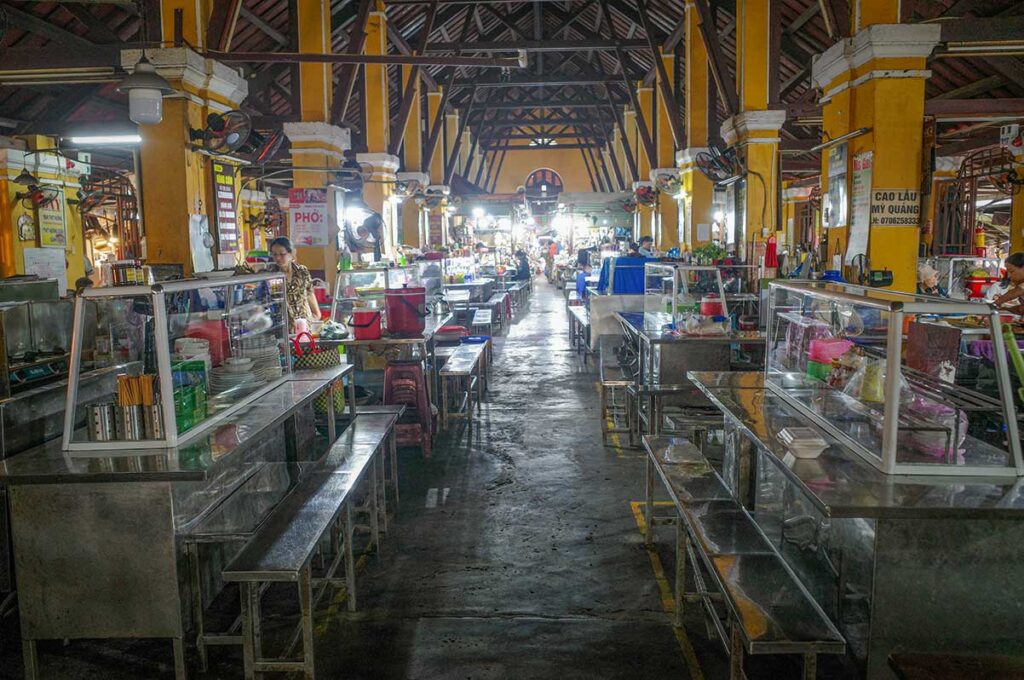 Hoi An Central Market food court with local dishes – Long rows of food stalls inside the market, serving traditional specialties like cao lầu and mì Quảng.
