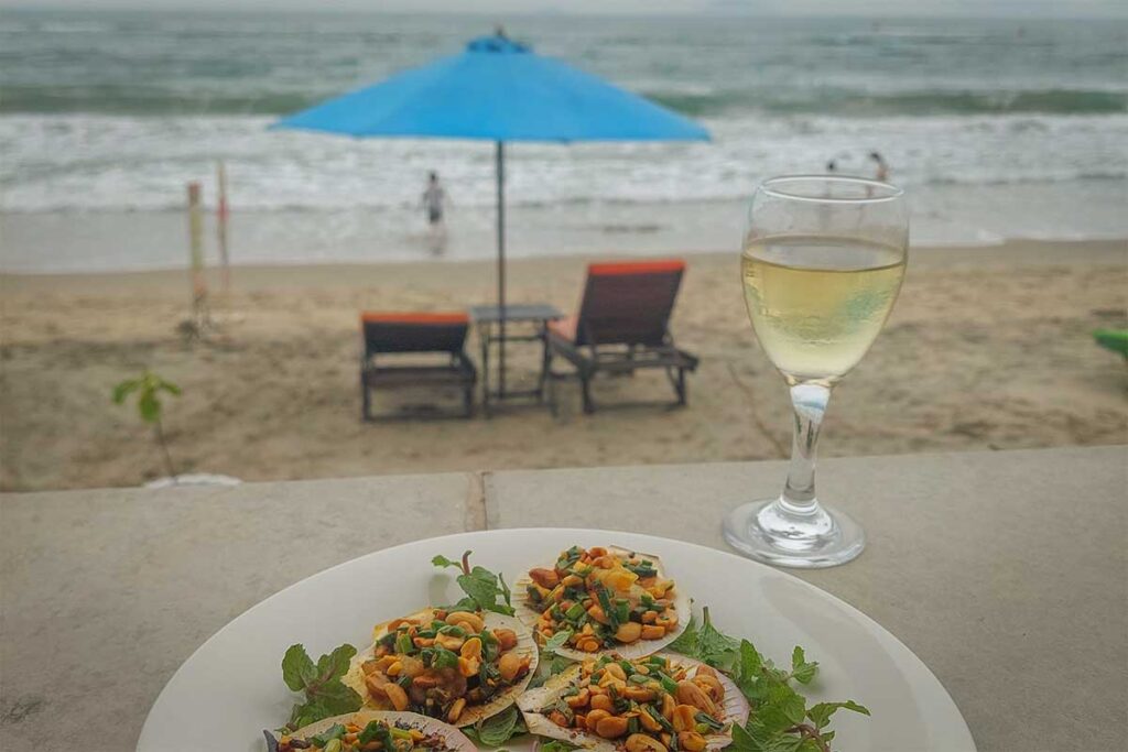 Hoi An Hidden Beach seafood restaurant view – Fresh seafood served at a beachside restaurant on Hidden Beach in Hoi An, paired with wine and ocean views.