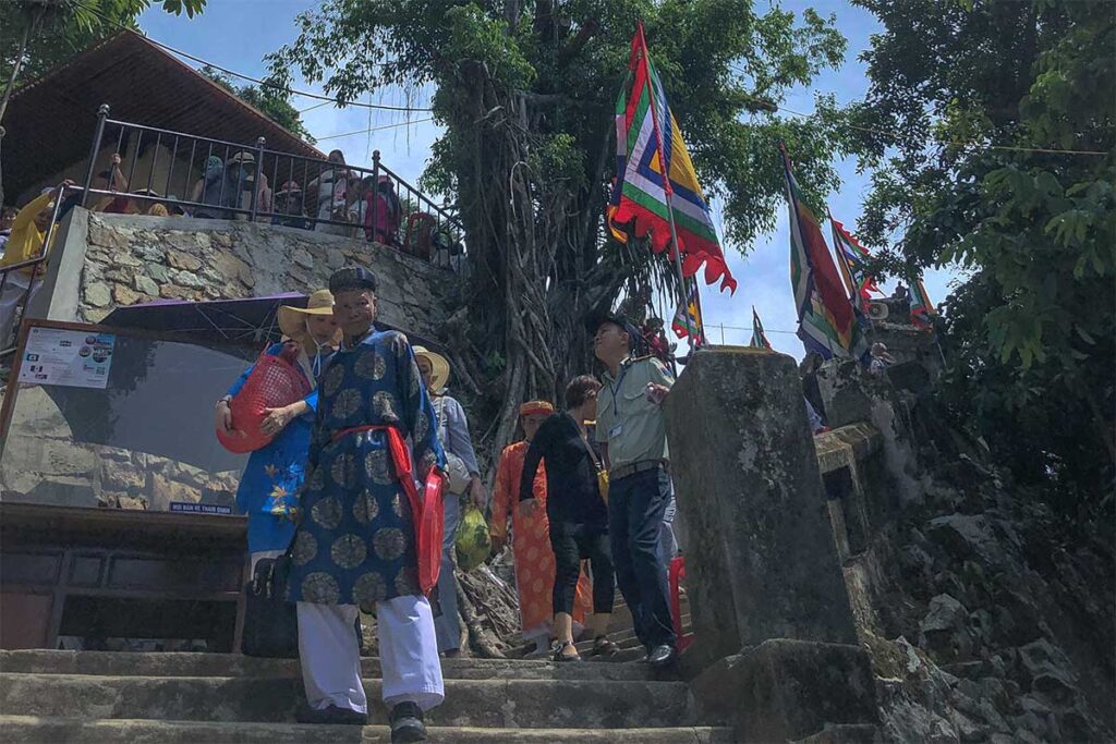 Few people dressed in traditional temple clothes climbing the stairs down at the temple of Hon Chen Festival