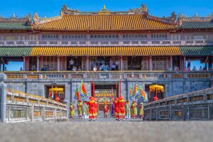 People wearing historical and Traditional clothes in front of the main gate of Hue Imperial City doing a performance during Hue Festival