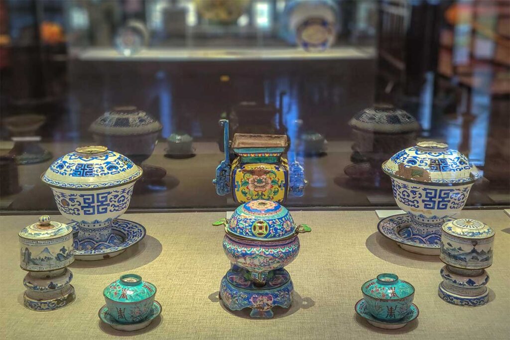 A old preserved ceramic set of Nguyen Dynasty era displayed behind glass in the Hue Museum of Royal Antiquities