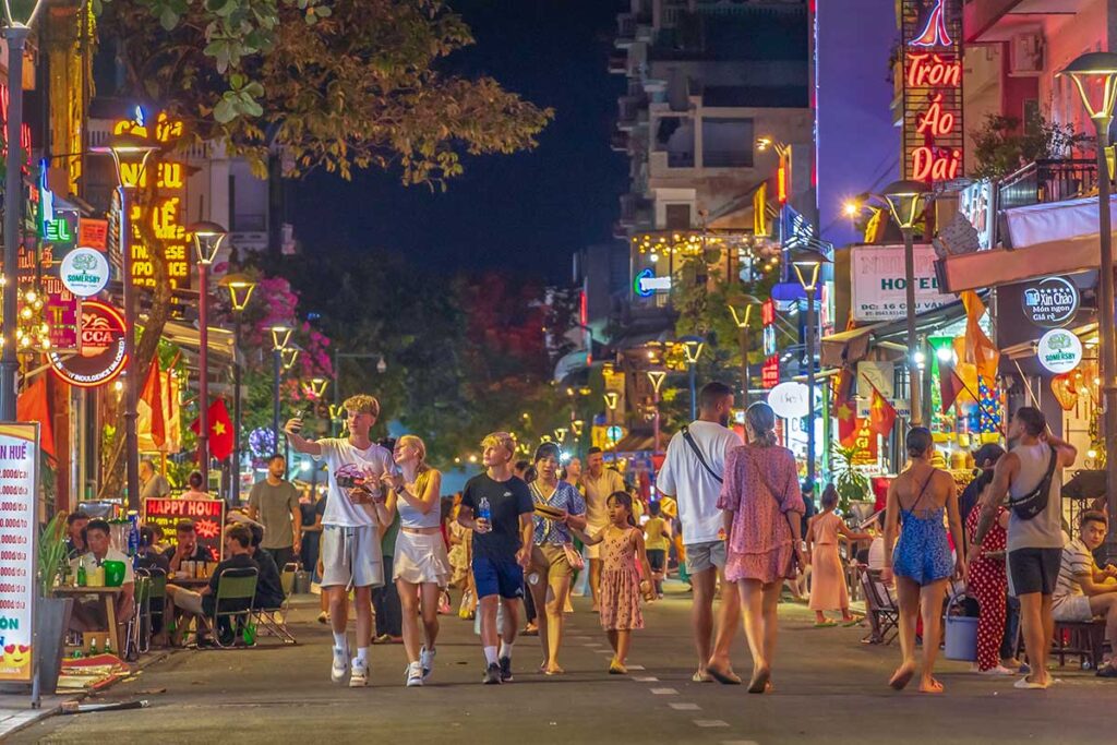 Tourists walking on the street of Hue Night Walking Street with bars and led lights