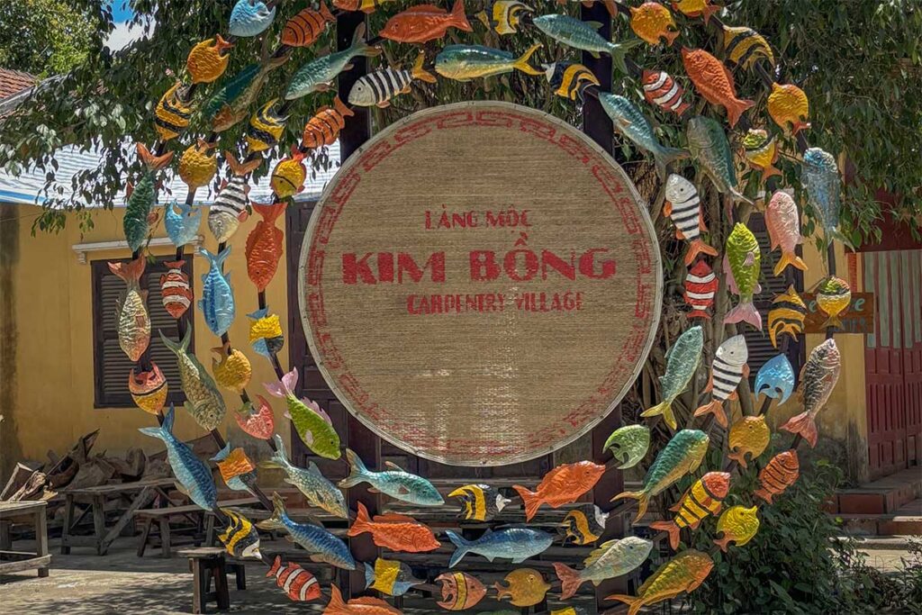 Colorful entrance sign decorated with painted fish at Kim Bong Carpentry Village, Hoi An.