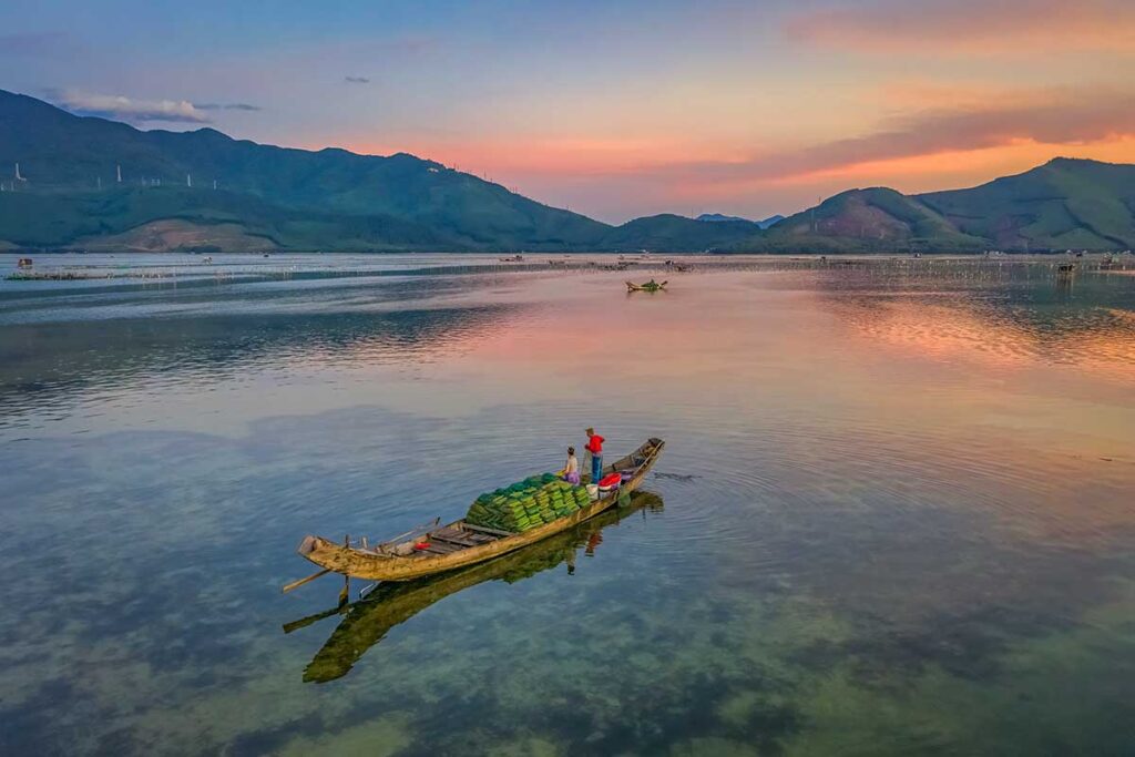 View during sunset with local small wooden fishing boat on Lap An Lagoon