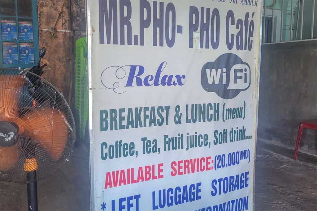 A sign of Mr Pho local restaurant opposite of Hue train station indicating food options and luggage storage