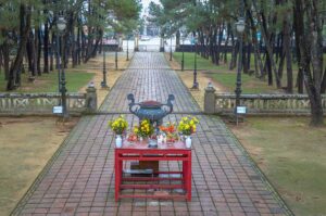 A small altar with bronze incense burner overlooking a straight stone path through a park called Nam Giao Esplanade