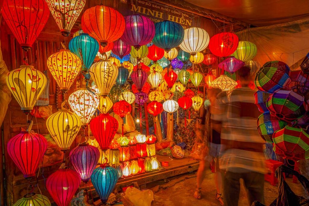 Colorful lantern shop at the night market in Hoi An Old Town, filled with traditional handmade silk lanterns glowing in warm evening light.