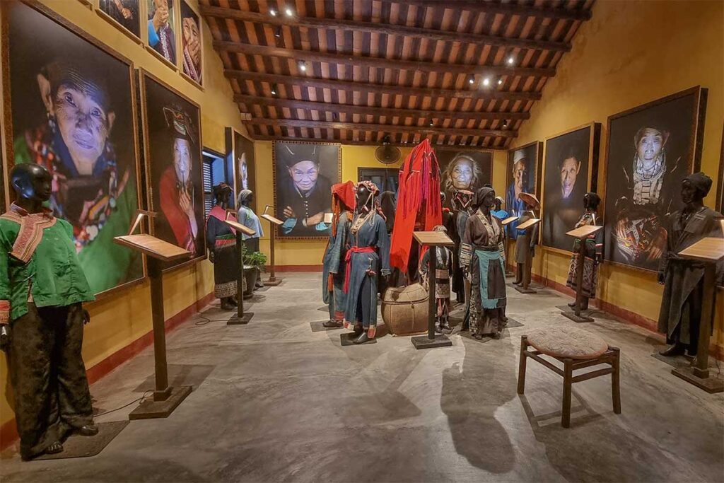 Ethnic minority costumes at Precious Heritage Museum Hoi An – Mannequins dressed in authentic tribal outfits surrounded by large photographic portraits.
