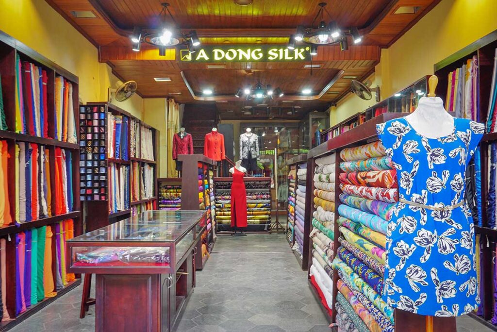A Dong Silk tailor shop in Hoi An Ancient Town, displaying vibrant fabrics and custom-made clothing, highlighting the town’s famous tailoring tradition.