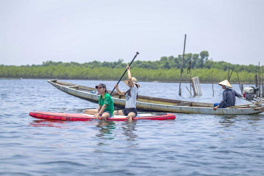 Tourists on a stand-up paddle board on Tam Giang Lagoon