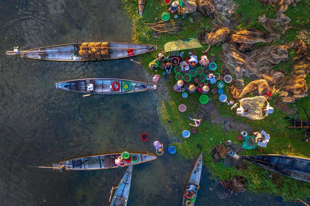 Drone view of local fishermen come on shore of Tam Giang Lagoon to bring their catch on land