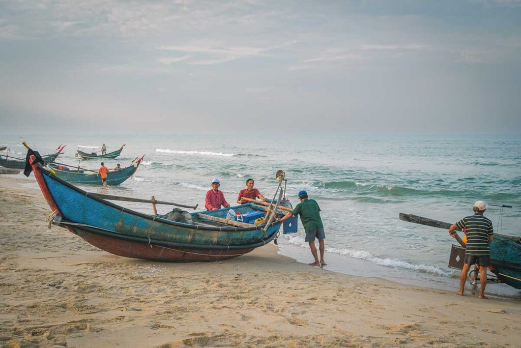 Fishing boats resting on the golden sands of Tam Thanh Beach, a peaceful seaside escape near Tam Ky.