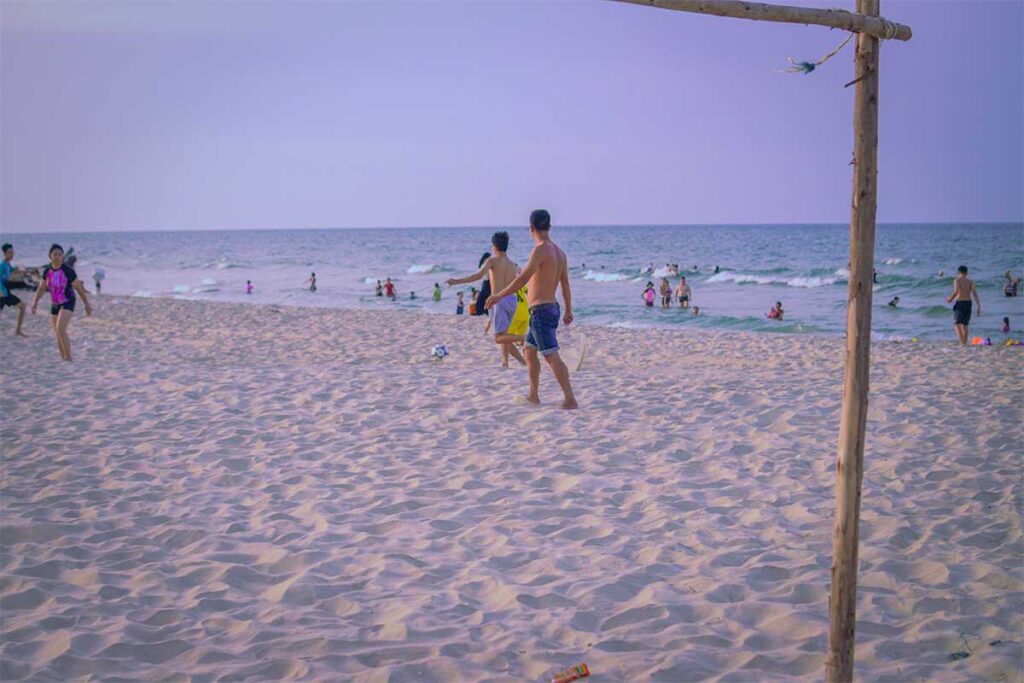 Local kids playing football on Tan An Beach in Hue