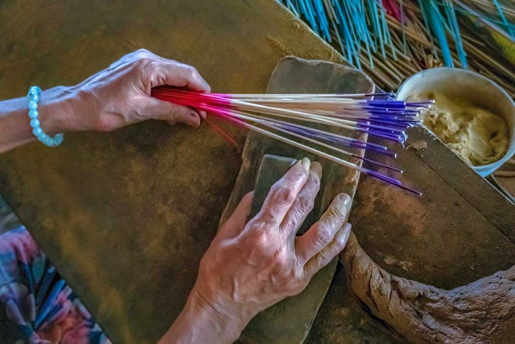 A hand is holding incense and tools to make it at Thuy Xuan Incense Village n Hue 