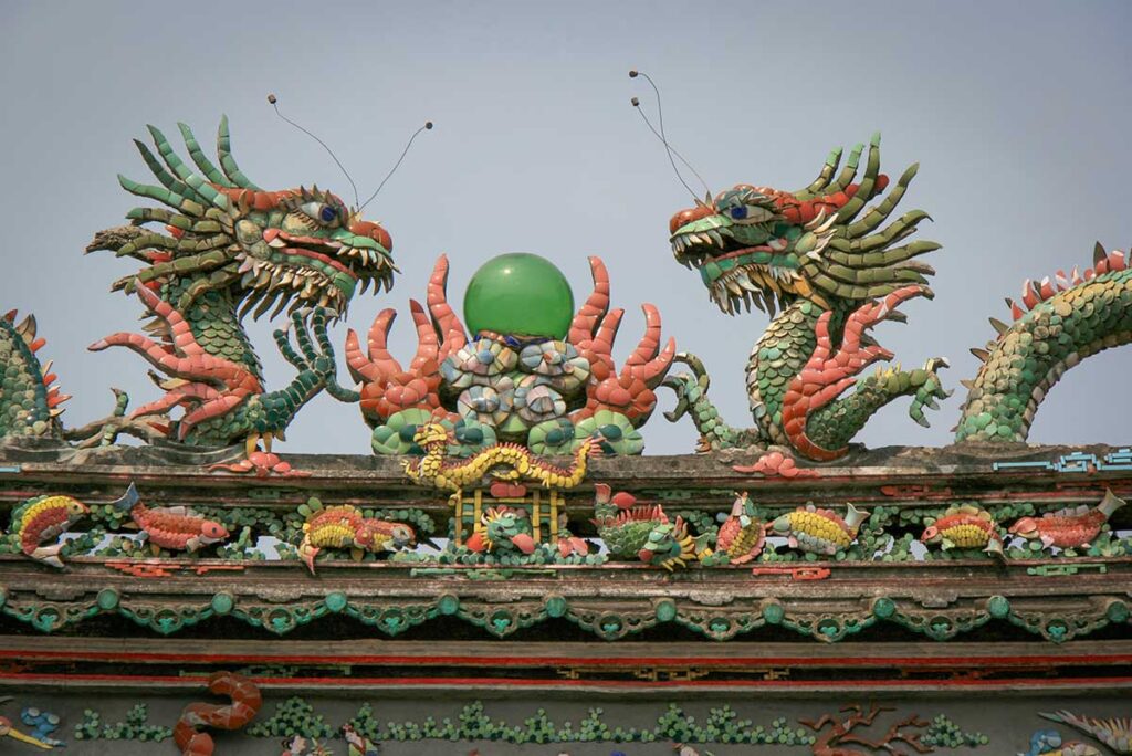 Twin dragon mosaics on the roof of Trieu Chau Assembly Hall in Hoi An, symbolizing power and protection