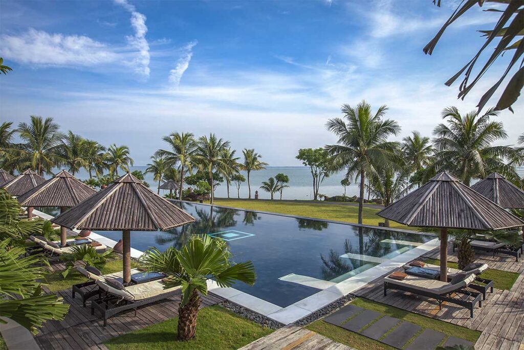 The pool of Vedana Lagoon Resort & Spa with in the background Tam Giang Lagoon