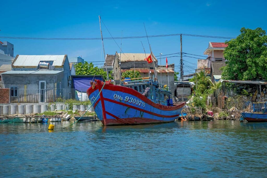 Fishing boat docked along the river in Cam Thanh Village, offering a glimpse of daily local life in Cam Thanh Coconut Village near Hoi An
