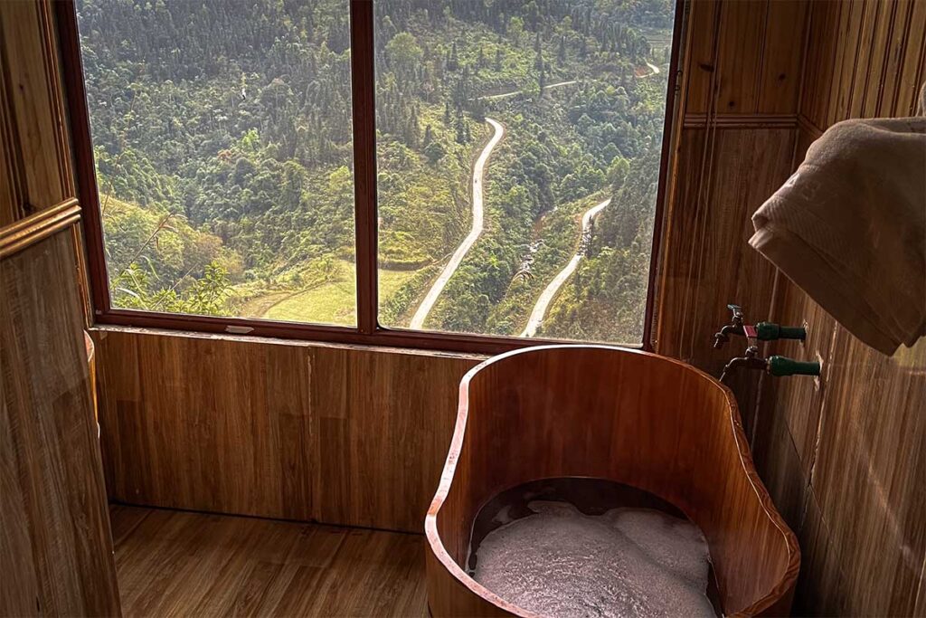 A Red Dao herbal bath inside with a window showing stunning mountains