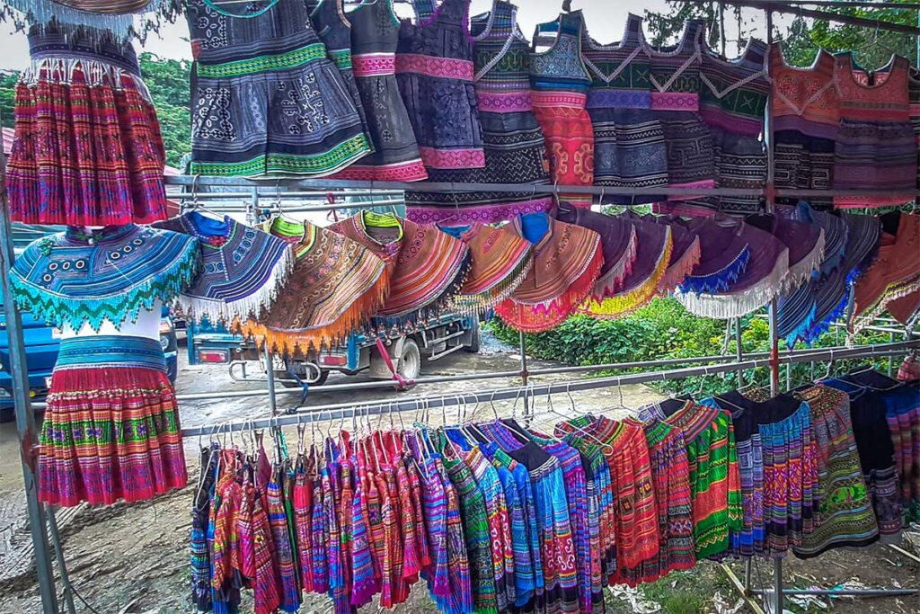 Colorful ethnic clothes hanging at a stall at the Lung Khau Nhin Market