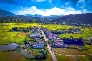 A road passing a small town and rice fields in Muong Than