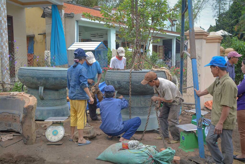 Artisans working on a massive bronze drum planter at Phuoc Kieu Bronze Casting Village, Hoi An.