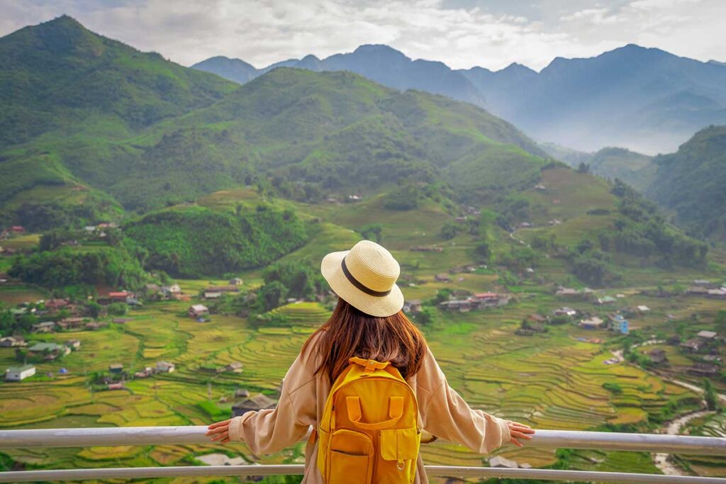 Tourist enjoying panoramic mountain and rice terrace views in Sapa on an easy sightseeing tour by car.
