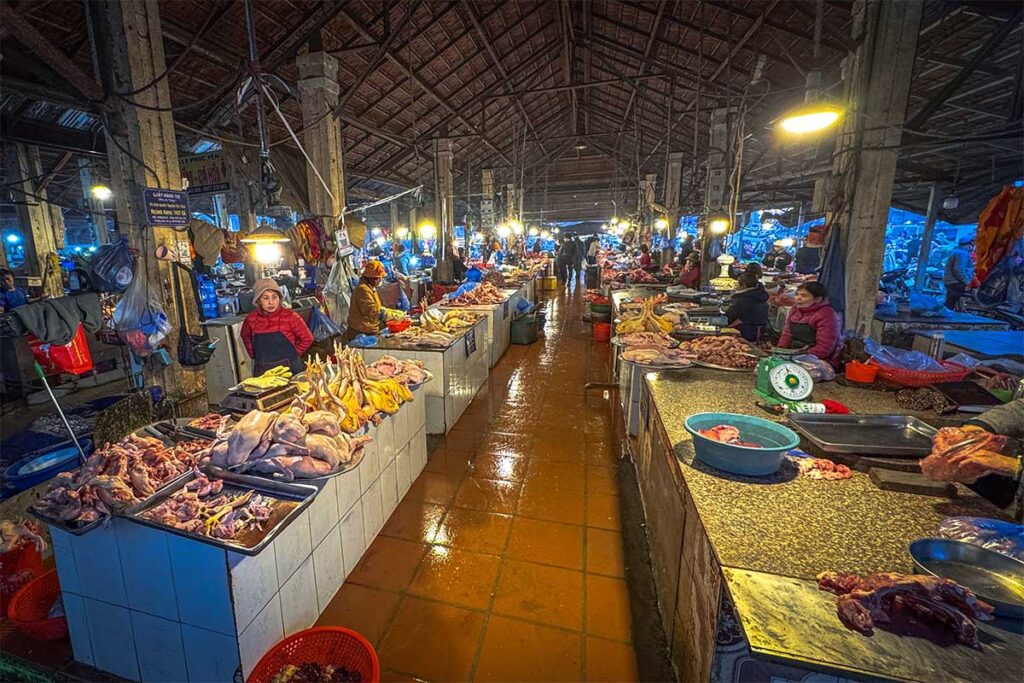 Meat being sold at long tables inside Sapa Market