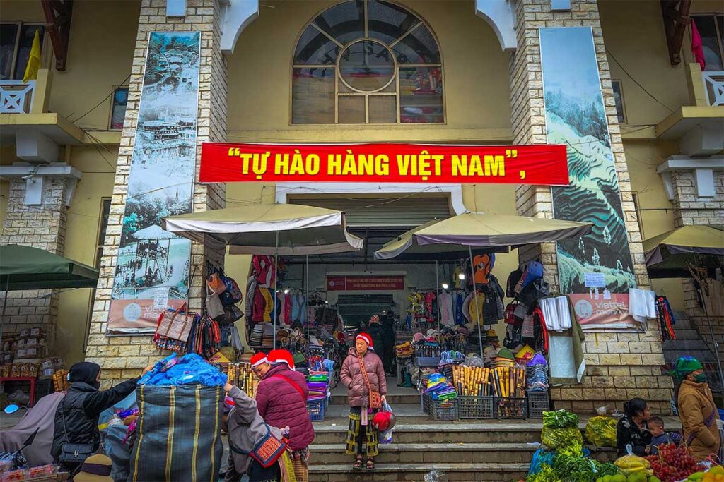 Entrance of Sapa Market with a few ethnic Red Dao woman coming outside the building
