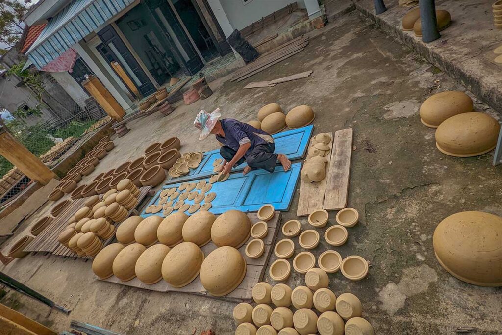 Local potter shaping clay pots at Thanh Ha Pottery Village – an authentic Hoi An village where handmade ceramics are still produced using traditional methods.