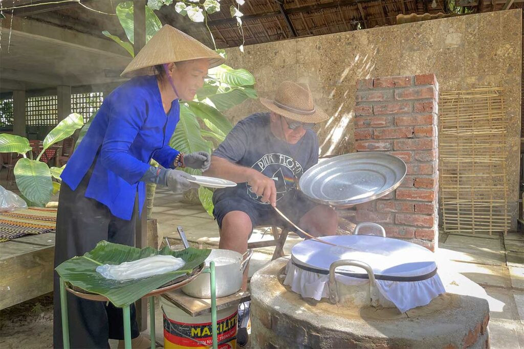 Traveler learning to make rice paper with a local host in Triem Tay Village – a peaceful riverside community around Hoi An.