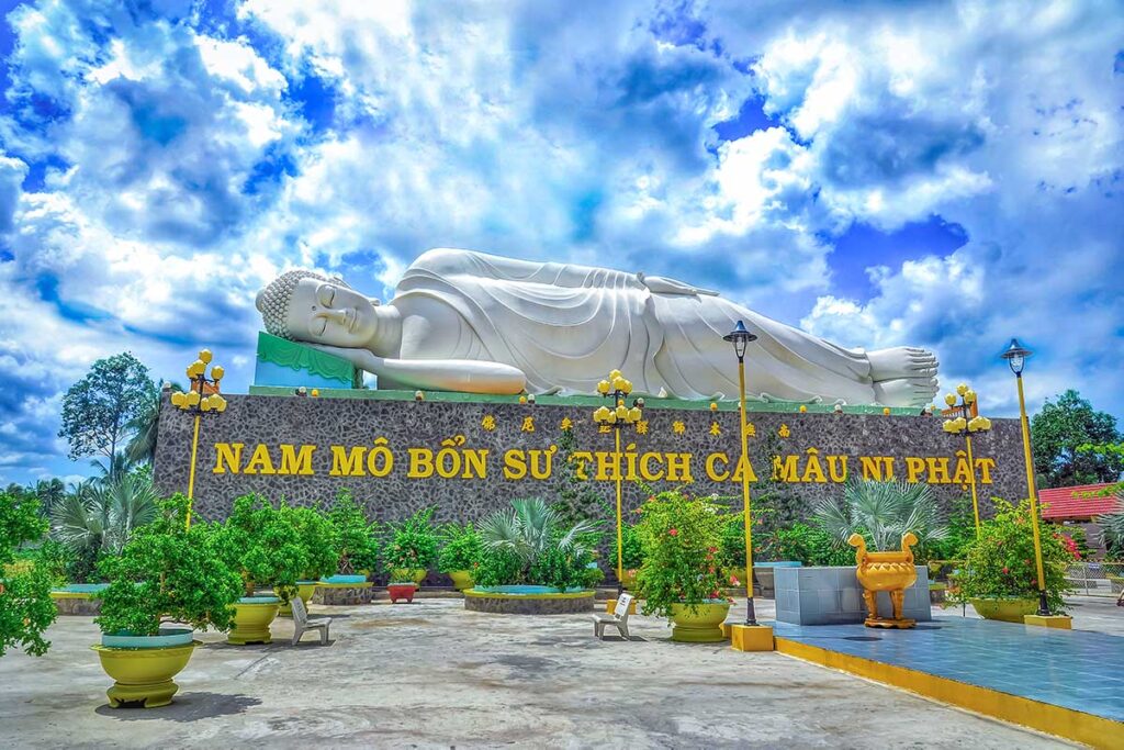 Reclining Shakyamuni Buddha statue at Vinh Trang Pagoda in My Tho, Vietnam, symbolizing the Buddha’s passing into Nirvana.