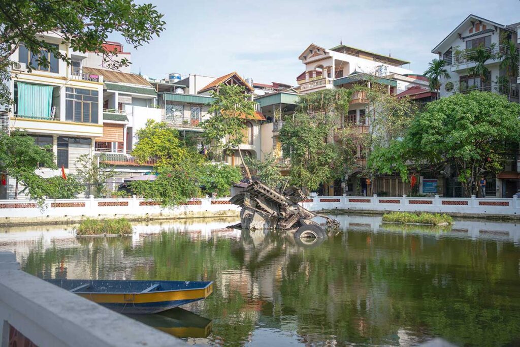 B-52 Lake in Hanoi with a crashed B-52 plane sticking out of the water of the lake which is surrounded by residential buildings