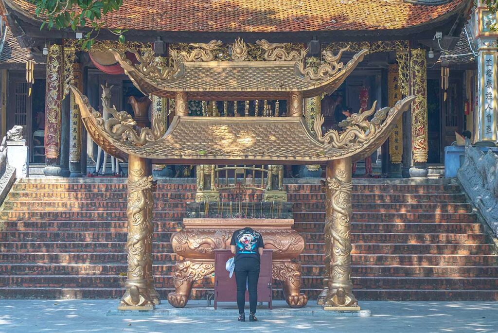 A man praying at the shrine in front of the main building of Ba Chua Kho Temple