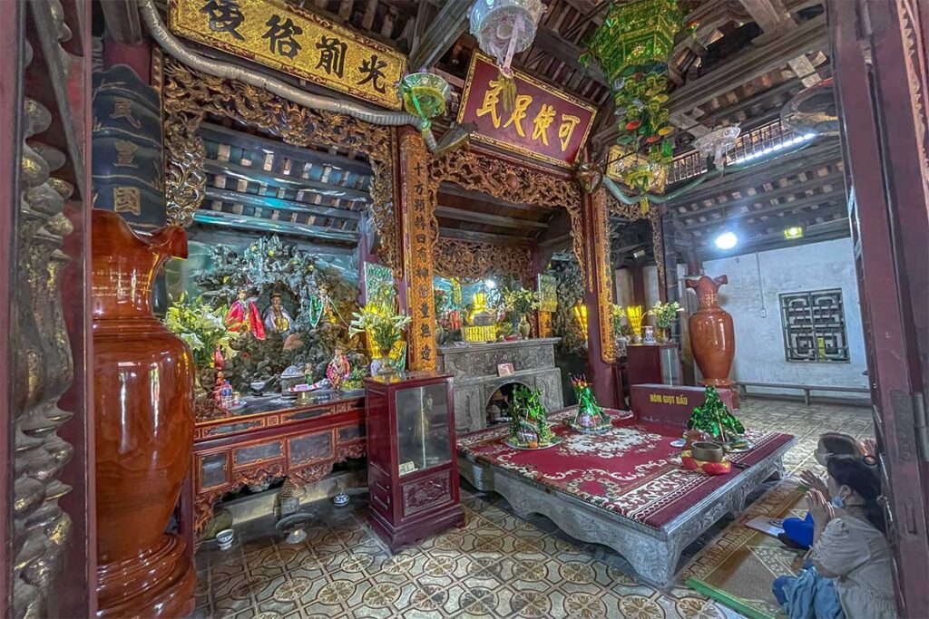 People inside the Ba Chua Kho Temple are praying at an altar