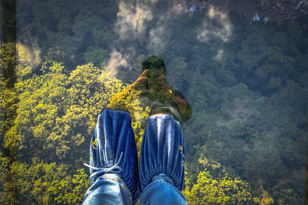 Two feet packed to keep the glass clean standing on the Bach Long Glass Bridge in Moc Chau - The world's longest glass bridge