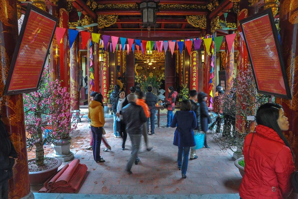 People praying and walking in and out inside the Bach Ma Temple