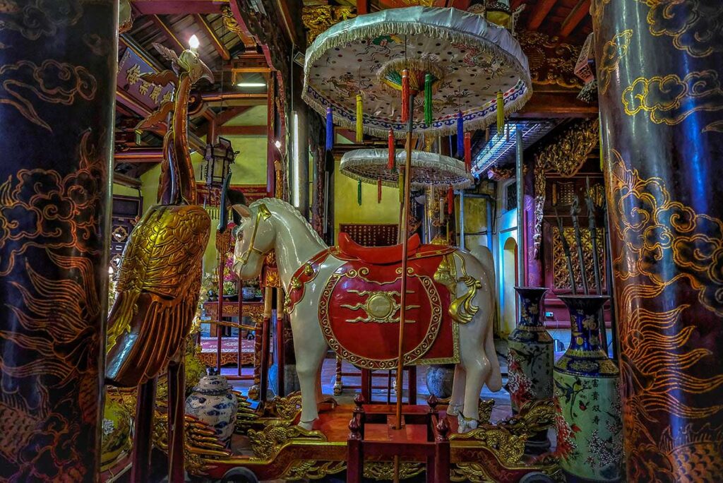 A statue of a white horse placed on an altar inside Bach Ma Temple in Hanoi