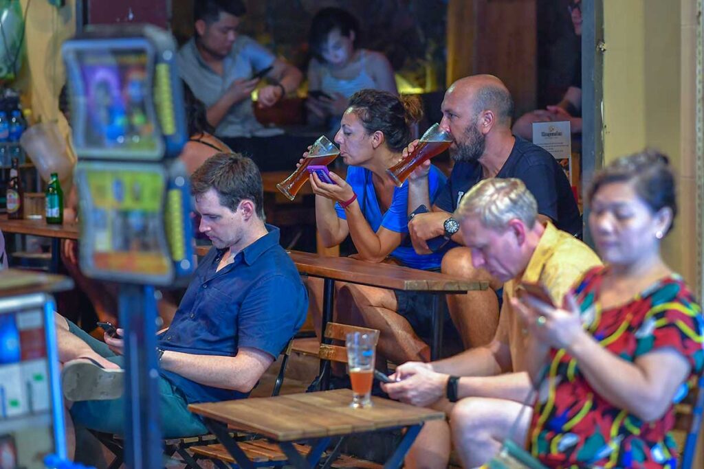 Tourists sitting at a local bar at Bia Hoi Corner (Bia Hoi Junction) drinking beer