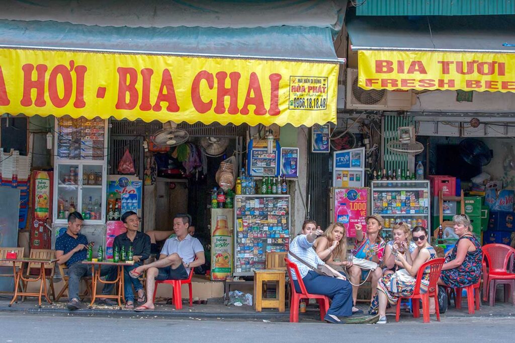 Tourists drinking Bia Hoi at a local bar in Hanoi