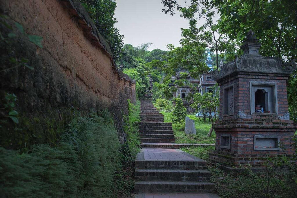Stupa garden on one side and on the other side earth walls part of Bo Da Pagoda, the path is leading into a forest