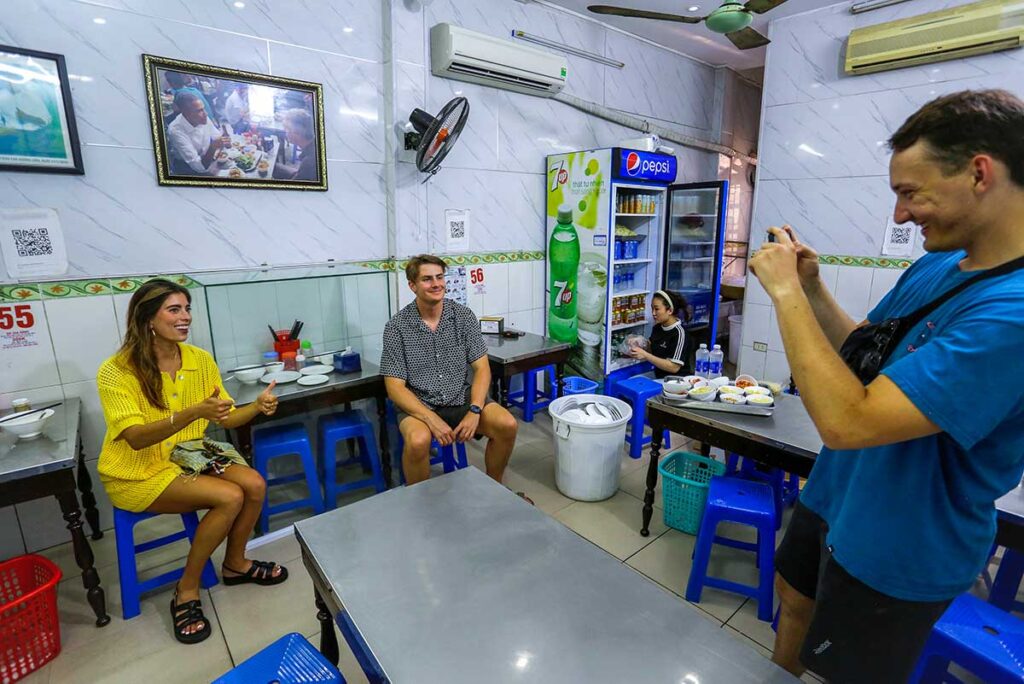 Tourists taking a photo with the spot wear Obama and Anthony ate at the Bun Cha restaurant now often referred to as Obama Restaurant Hanoi