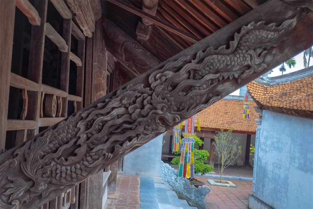 A wooden beam supporting the roof of one of the temples inside But Thap Pagoda with beautiful wooden carvings