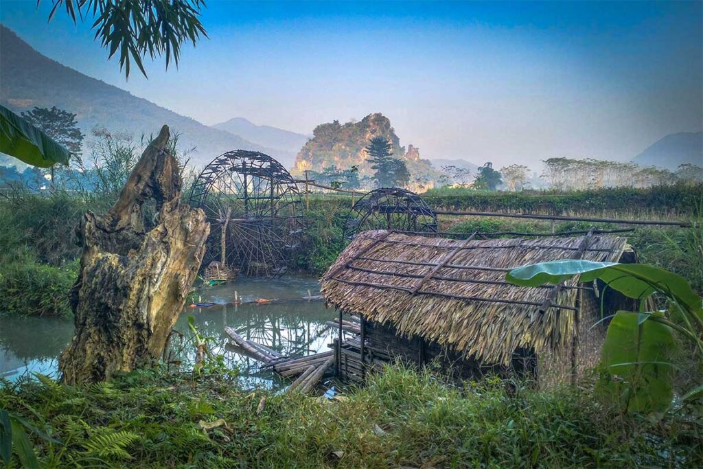 Water wheels and a bamboo raft along the Cham Stream in Pu Luong