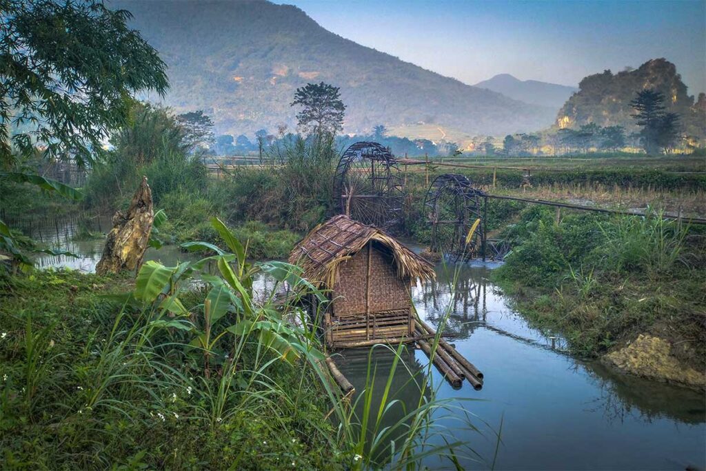 Water wheels and a bamboo raft along the Cham Stream in Pu Luong
