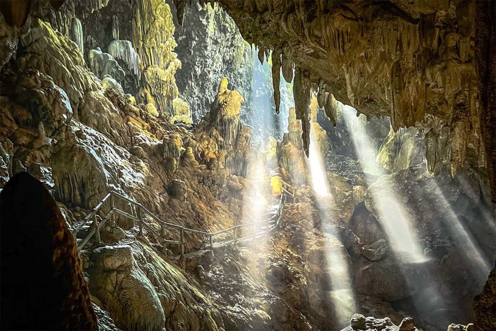 Stunning light beams shining through the Chieu Cave ceiling