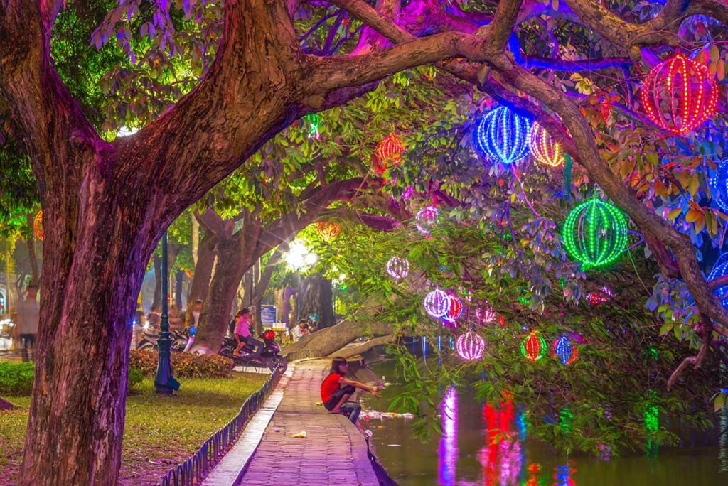 Christmas decorations hanging in the trees around Hoan Kiem Lake