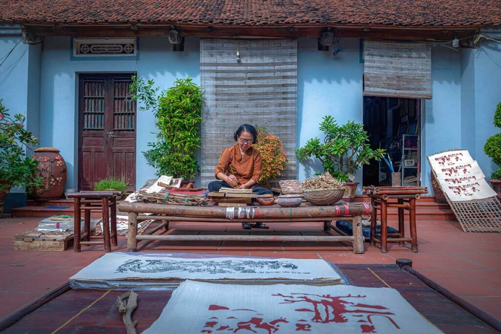 A woman making a traditional Dong Ho Painting at a local house in Dong Ho Painting Village